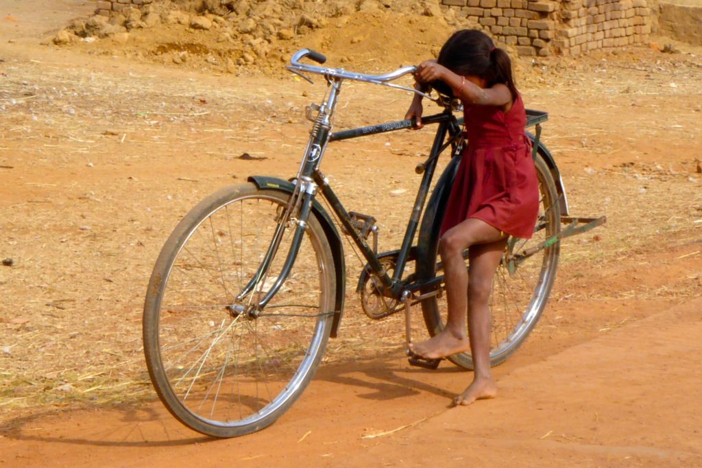 Straßenfotografie in Indien unter dem Motto aller Anfang ist schwer. Mädchen mit Fahrrad.