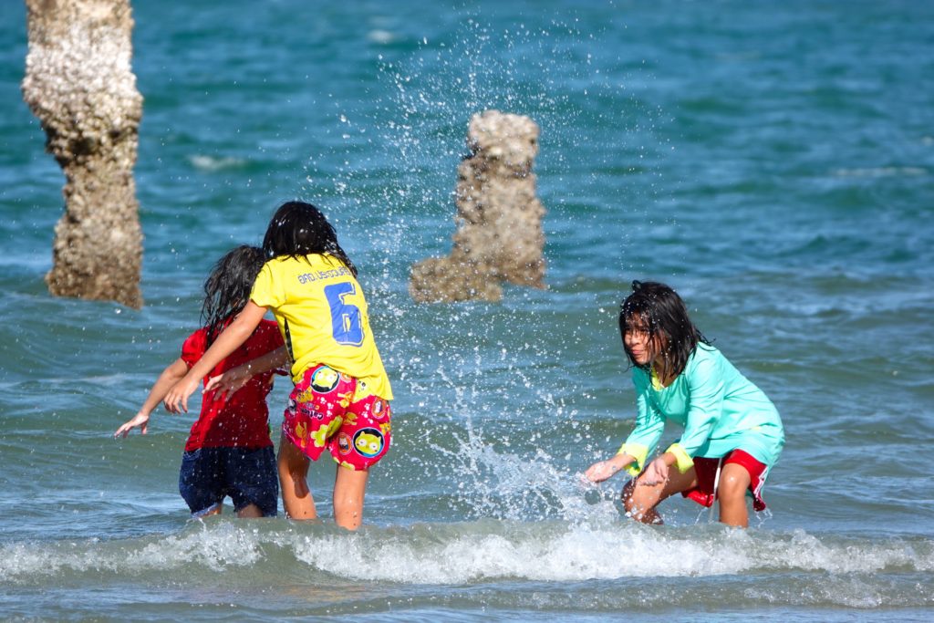Kinder in Hua Hin beim Planschen im Meer.