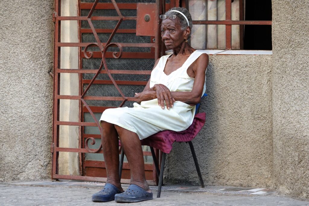 Havanna: Frau sitzt vor dem Haus.